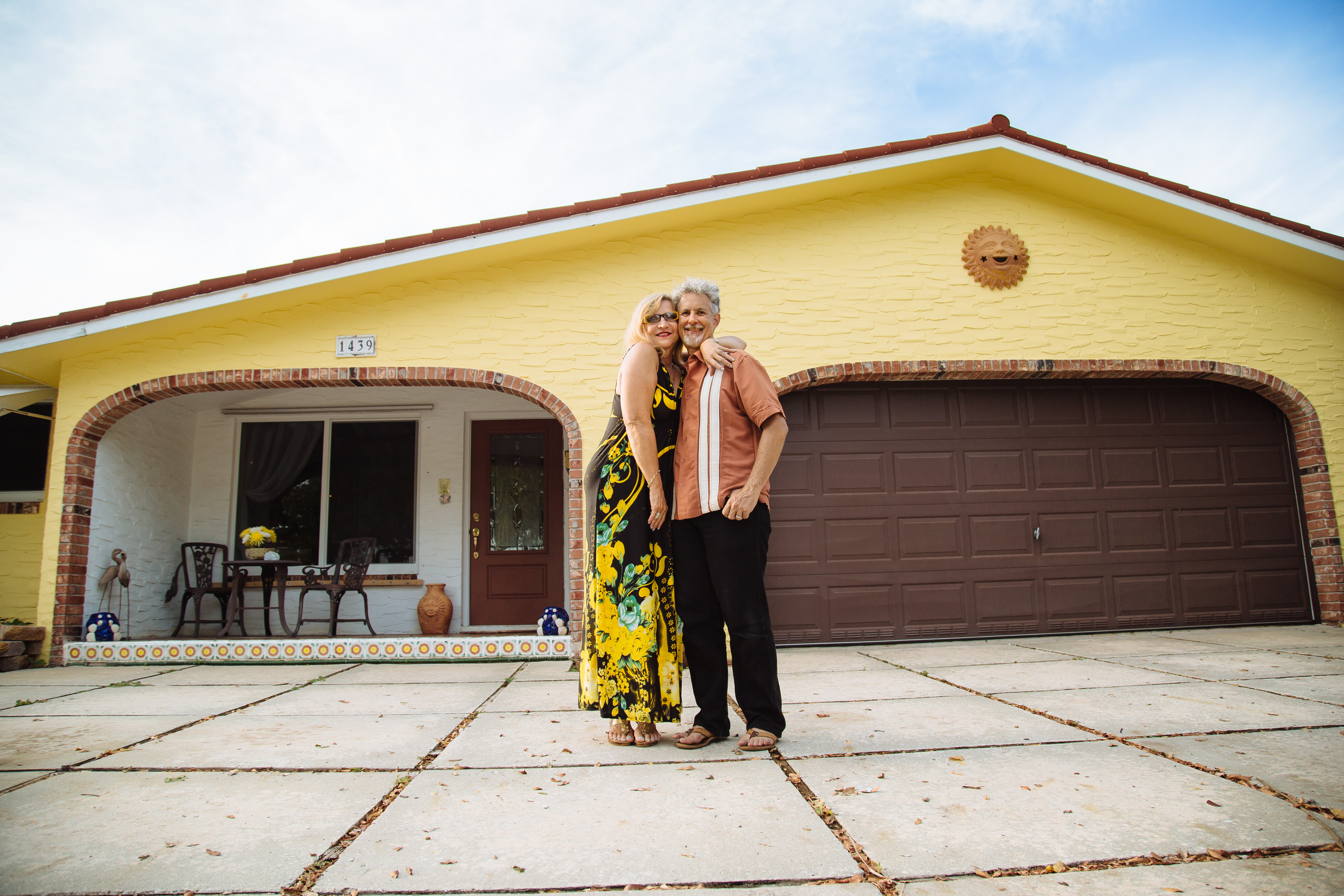 Happy couple in front of Florida home with new energy-efficient upgrades